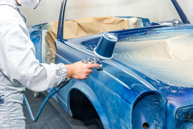 Auto body technician spray painting a car