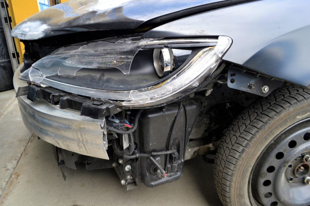 A car with a broken headlight and visible damage, representing the importance of bumper repairs in Melbourne.